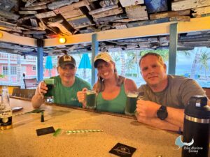 Three Blue Horizon guests raising green drinks at the Little Cayman Beach Resort beach bar
